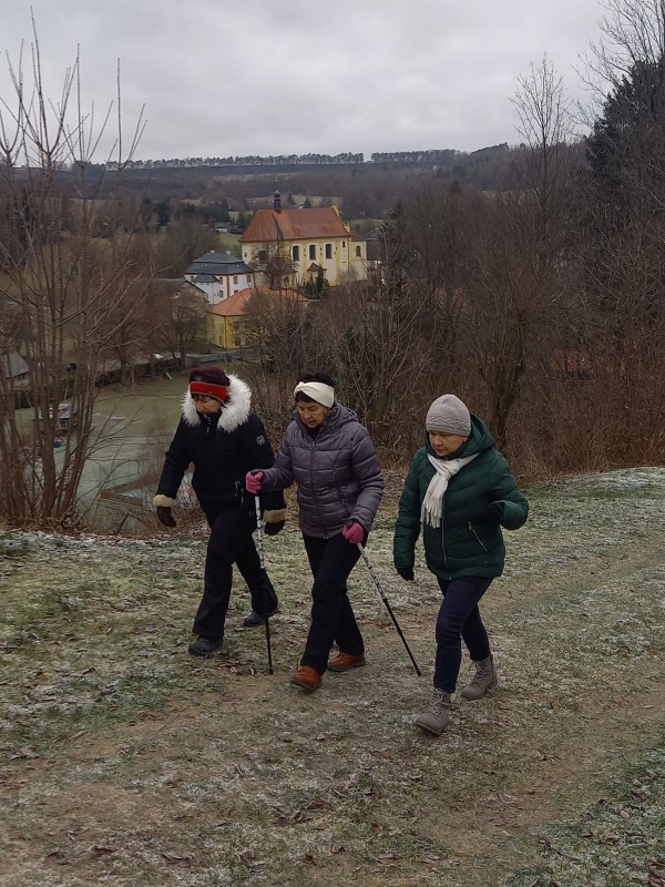 Tři ženy jdou zimní krajinou během štěpánského pochodu.